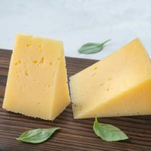 a couple of pieces of cheese sitting on top of a wooden cutting board